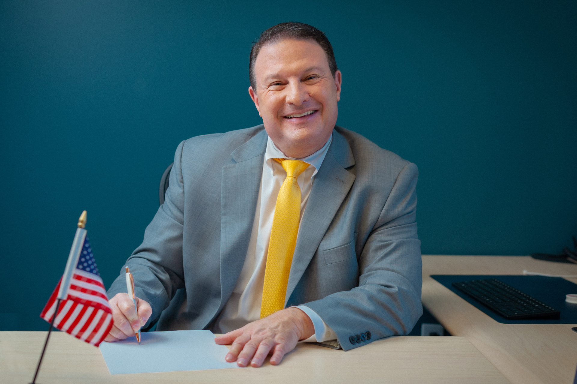 Immigration lawyer Adam Elman reviewing and signing new immigration documents at his office desk.
